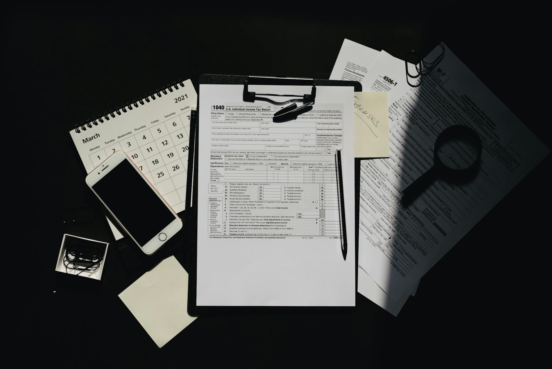 Dokumenty podatkowe, kalendarz i telefon na biurku małej firmy