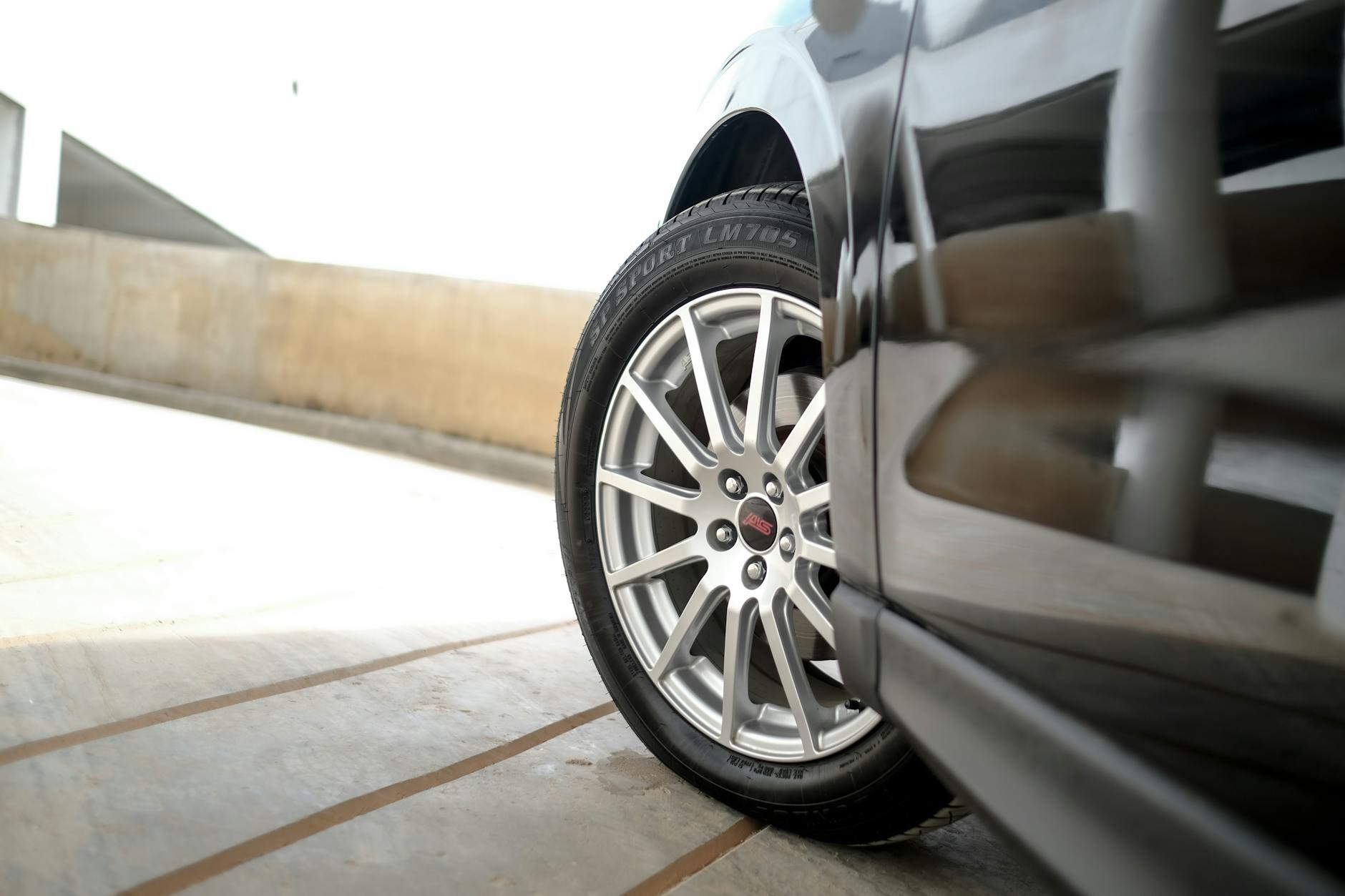 Zbliżenie na aluminiową felgę samochodu z odbijającym światłem lakierem