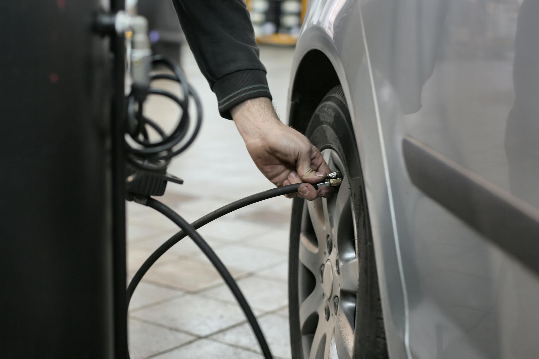 Mechanik pompuje oponę w warsztacie, sprawdzając jej ciśnienie